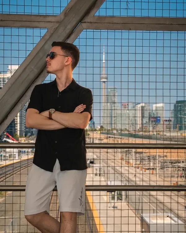 Matheus Bazarin Ribeiro on a rooftop in Toronto, arms crossed
